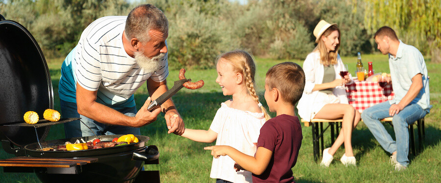 father grilling with children