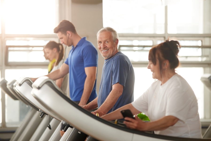 Older man walking on a treadmill.