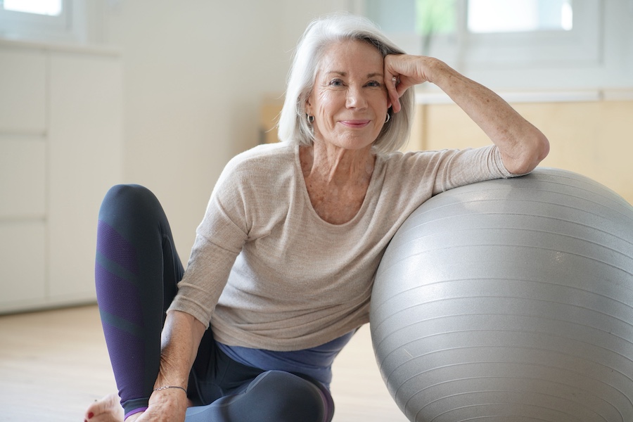 Smiling woman with yoga ball