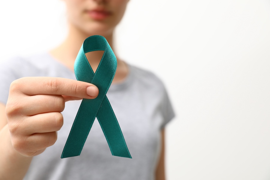 Woman holding teal awareness ribbon