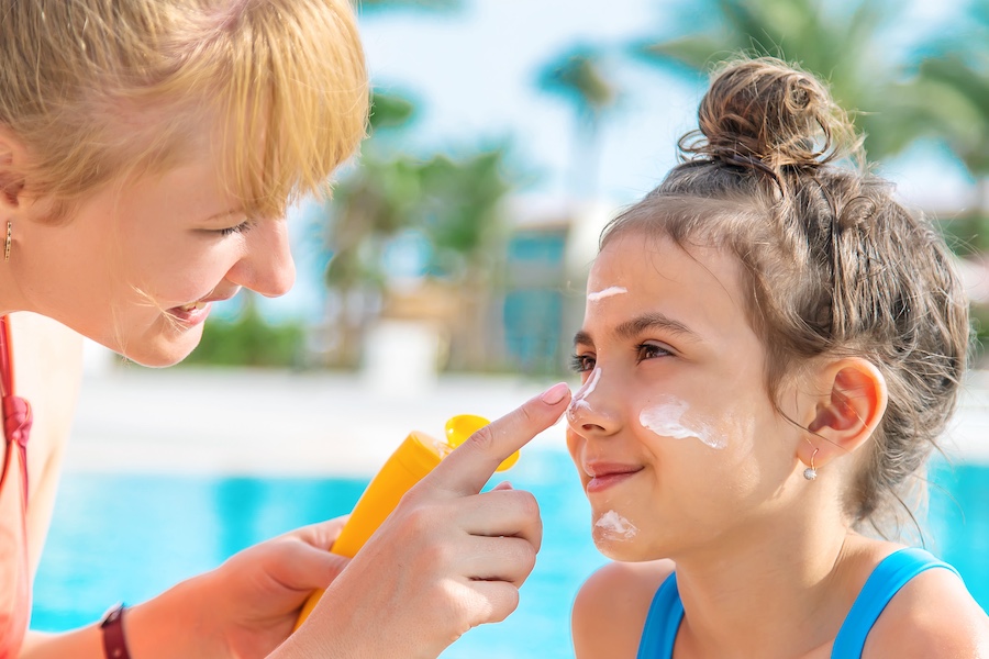 Mother applying sunscreen to child