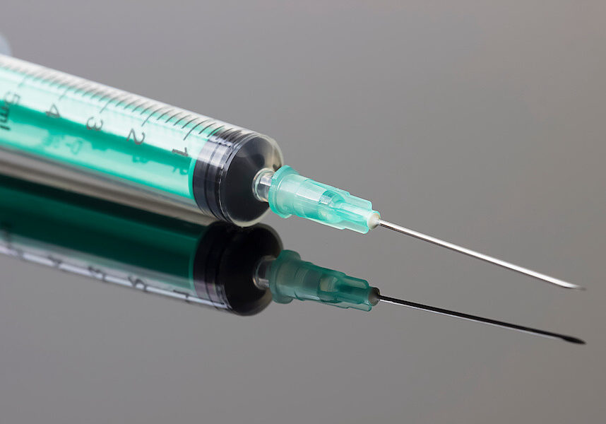Medical syringe on a gray background. Concept of medicine and health.
