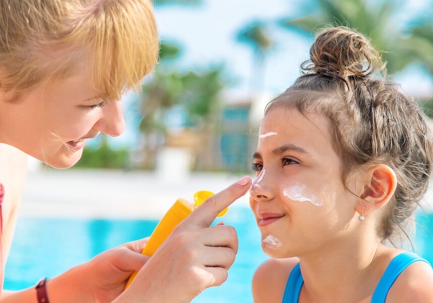 Mother applying sunscreen to child