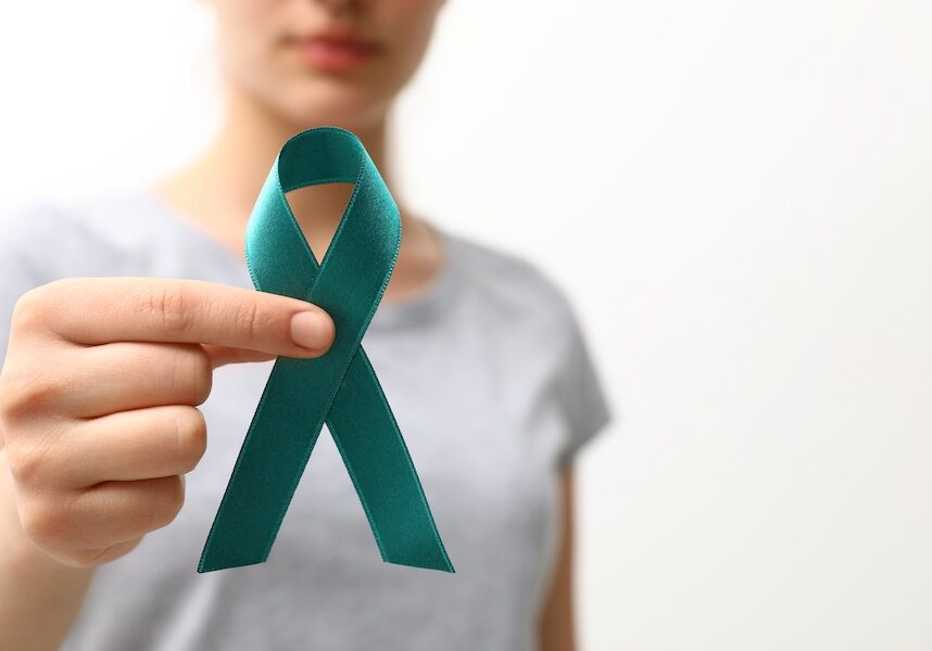 Woman holding teal awareness ribbon