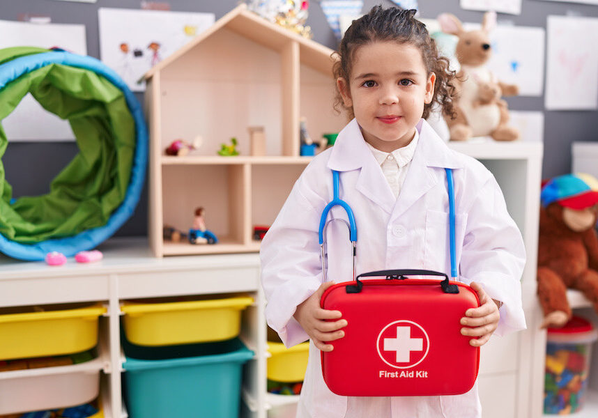 girl wearing doctor uniform holding first kit